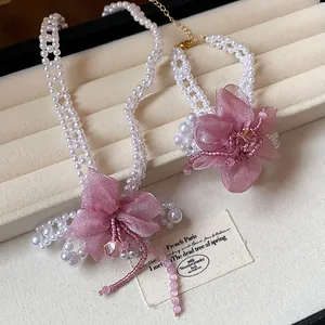 Detailed view of the chiffon flower and pearl necklace and bracelet jewelry set