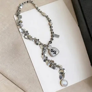 Silver tassel necklace with sparkling rhinestone money bag pendant and white pearl