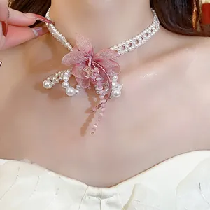 Detailed view of elegant pearl choker featuring a delicate pink chiffon flower ornament
