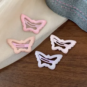 Close-up detail of four colorful butterfly-shaped snap hair clips on textured background