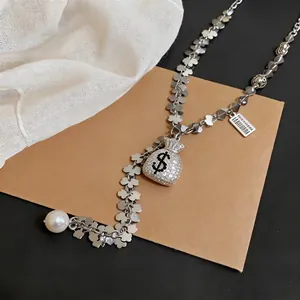 Sparkling crystal money bag tassel necklace with clover chain and pearl drop pendant.