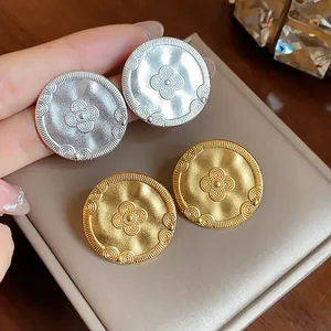 Vintage matte gold and silver round stud earrings with an embossed floral pattern