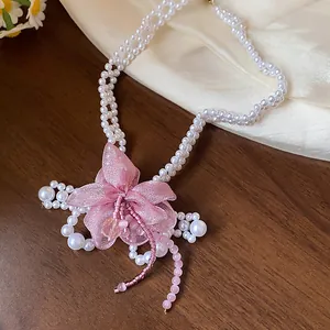 Detailed close-up of the delicate pink chiffon flower on this pearl beaded necklace