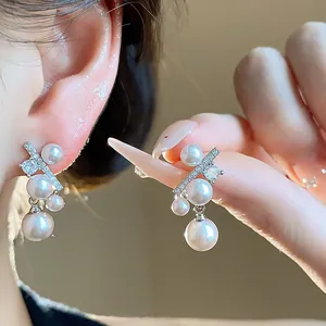 Primo piano dettagliato di eleganti orecchini a perno in argento con perle e zirconi.