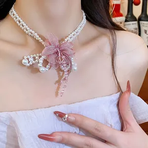 Detailed macro view of an elegant chiffon flower and pearl necklace with bead tassels