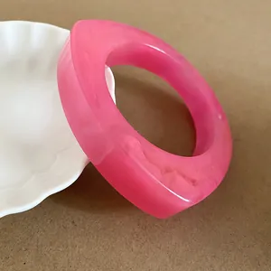 Macro view of a stylish pink resin bangle with unique irregular geometric design