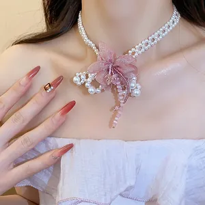 Close-up of an elegant pink chiffon flower pearl choker necklace with beaded tassels.