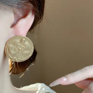 Detailed close-up of 18K gold plated matte stud earring with vintage textured print