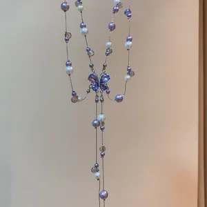 Detailed view of a purple crystal butterfly necklace with elegant pearls and beads adornments.