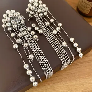 Close-up of elegant silver tassel earrings featuring beaded fringe and metallic texture