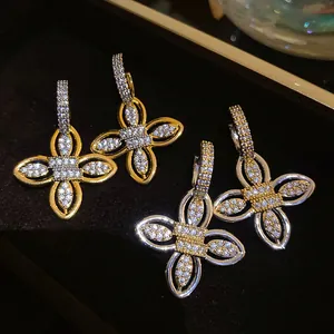 Gros plan de boucles d'oreilles fleurs en zircone étincelant plaqué or 18 carats
