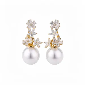 Elegant gold floral earrings with sparkling zircons and large white pearls on white background.