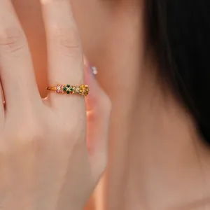 Elegant gold-plated band ring with colorful round zirconia stones shown on finger