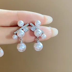 Dettaglio macro di eleganti orecchini in argento con perle lucenti e pietre di zircone
