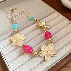 Vintage style gold flower pendant necklace with colorful resin beads in a jewelry box