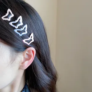 Close-up detail of four sweet colorful butterfly enamel hair clips on brown hair