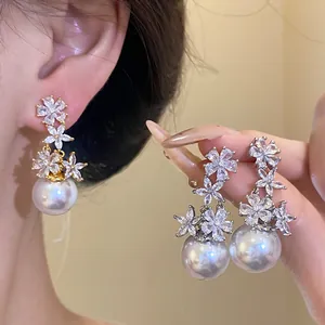 Macro detail of silver needle flower earrings with sparkling cubic zirconia and pearls