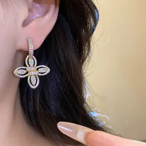 Détail d'une boucle d'oreille fleur en plaqué or 18 carats avec de la zircone cubique