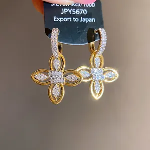 Vue détaillée de boucles d'oreilles fleuries plaquées or 18 carats et zircons