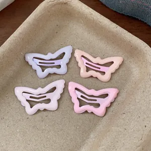 Detailed view of four colorful butterfly-shaped drip oil hair clips in pastel tones