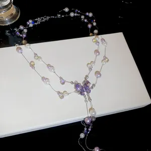 Detailed view of the purple crystal butterfly pendant and elegant pearl tassels