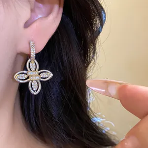 Détail de boucles d'oreilles fleur plaquées or 18k avec zircons brillants en vue macro.
