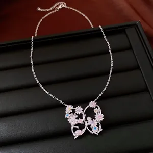 Détail du pendentif papillon orné de fleurs en zircon colorées sur chaîne argentée