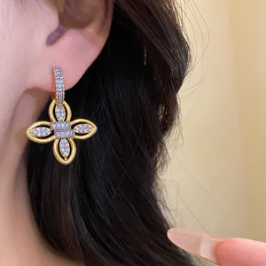 Vue détaillée des boucles d'oreilles fleur plaquées or 18k avec zircons étincelants