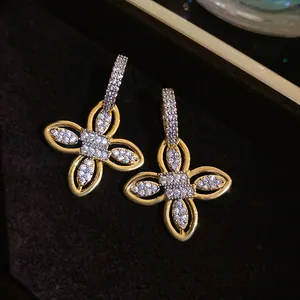 Détails rapprochés des boucles d'oreilles fleur plaquées or 18k avec pavé de zircons