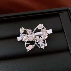 Vue détaillée de la pince à cheveux papillon argentée avec fleurs en zircon colorées sur fond