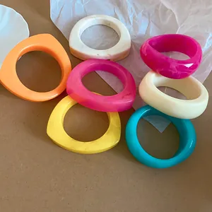 Close-up of vibrant irregular geometric resin bangles in multiple colors.