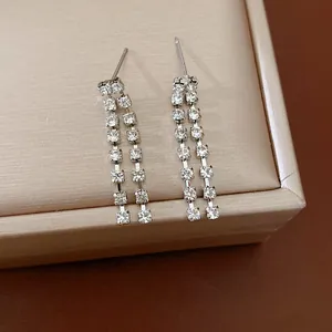 Primo piano dettagliato che mostra le nappe di strass argentati di questi eleganti orecchini