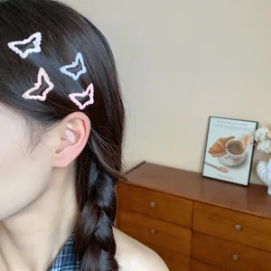 Set of 4 pastel butterfly-shaped enamel hair clips shown worn on model's hair detail view