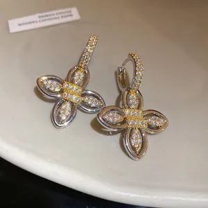 Vue macro détaillée de boucles d'oreilles créoles fleurs en zircon plaqué or 18 carats de luxe