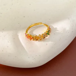Macro detail of gold adjustable ring featuring vibrant multi-colored zircon flower patterns.