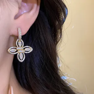 Détail de la boucle d'oreille fleur plaquée or sertie de zircones pavés