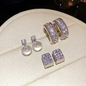 Elegante set di orecchini con strass argentati presentati su un vassoio portagioie chic