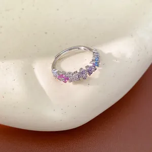 Macro view of a silver ring adorned with colorful flower-shaped cubic zirconia stones