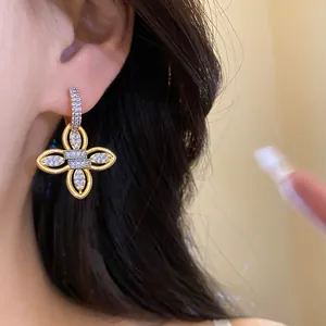 Gros plan détaillé de boucles d'oreilles fleur en zircon plaqué or 18 carats sur oreille