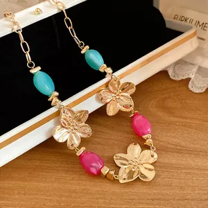 Detail view of vintage gold flower pendant necklace with vibrant blue and pink beads