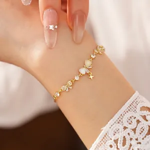 Elegant 18K gold plated bracelet featuring zircon bow and star charms on wrist.