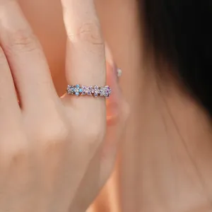 Close-up of silver ring with colorful flower-shaped cubic zirconia on finger