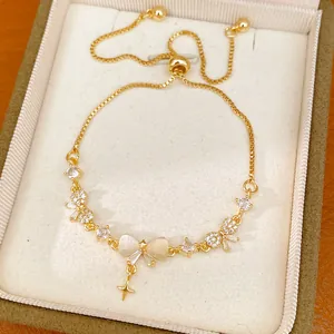 Close-up of 18K gold-plated bracelet with zircon bow and star pendant in a gift box