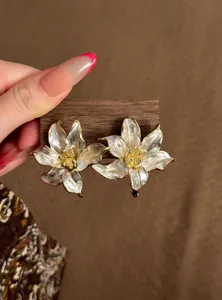 Elegantes pendientes de botón con flores blancas, borde dorado y pétalos de nácar