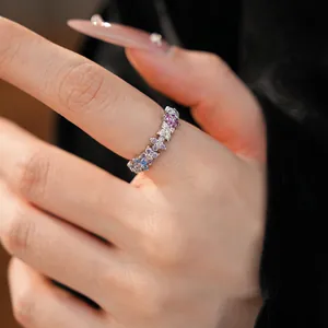 Close-up detail of a silver floral ring with gradient pink and blue cubic zirconia stones