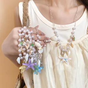 Detailed view of summer-style starfish and shell pearl necklaces worn by an Asian model.