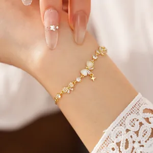 Detailed view of a gold-plated bow bracelet with cubic zirconia and starburst charm.