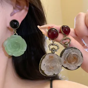 Detailed macro view of vintage resin rose earrings with metallic clock frame accents