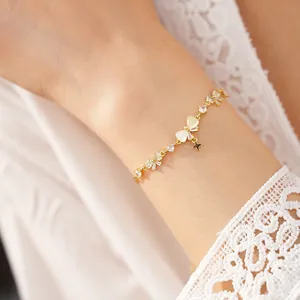 Close-up detail of 18K gold plated bracelet with zircon bow and star on wrist