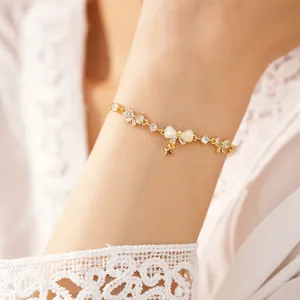 Detailed view of 18K gold-plated zircon bracelet with bow-knot and star charm